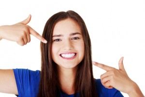 Beautiful woman pointing on her perfect white teeth.